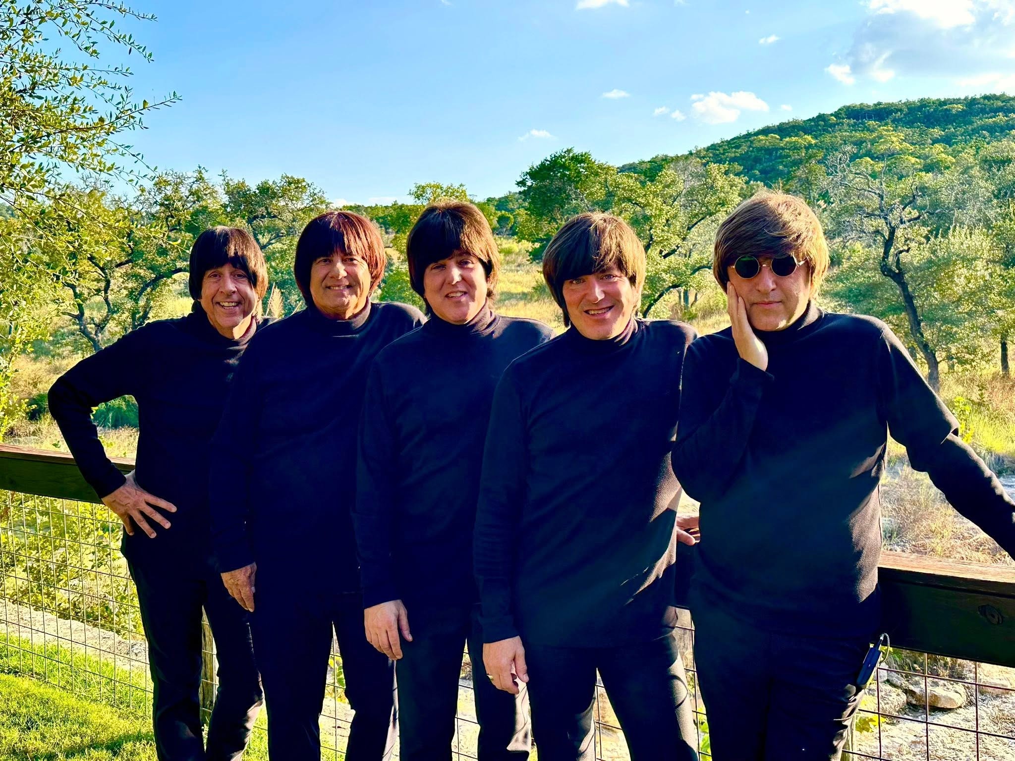 The Fab 5 in black turtlenecks with scenic landscape background