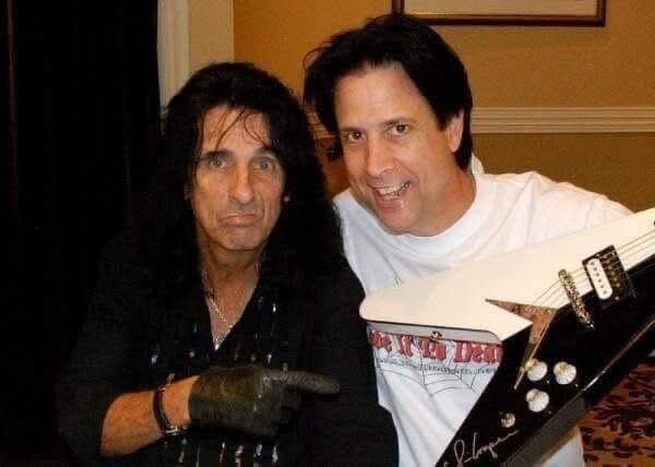 Alice Cooper holding a Fab 5 Fan Club member badge