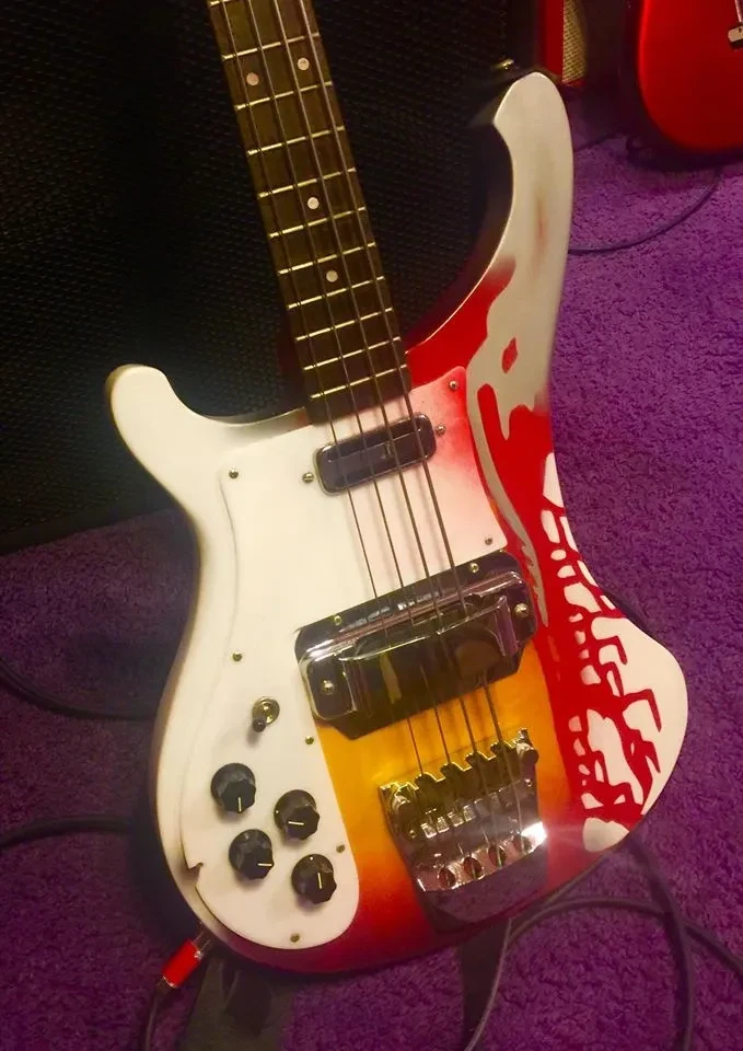 Red and white Rickenbacker bass guitar on stage