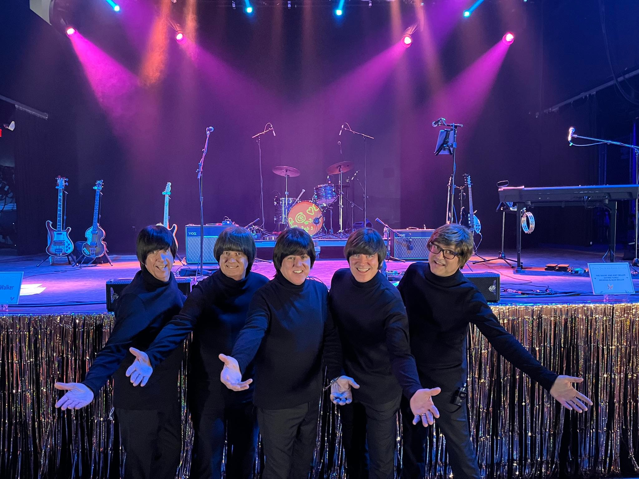 The Fab 5 performing on stage with purple and blue lighting